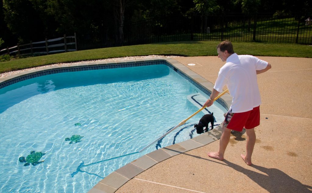 Pool technician cleaning a residential pool in Fair Oaks California